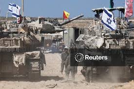 Israeli soldiers stand next to tanks near the Israel-Gaza border, in Israel | Reuters Connect
